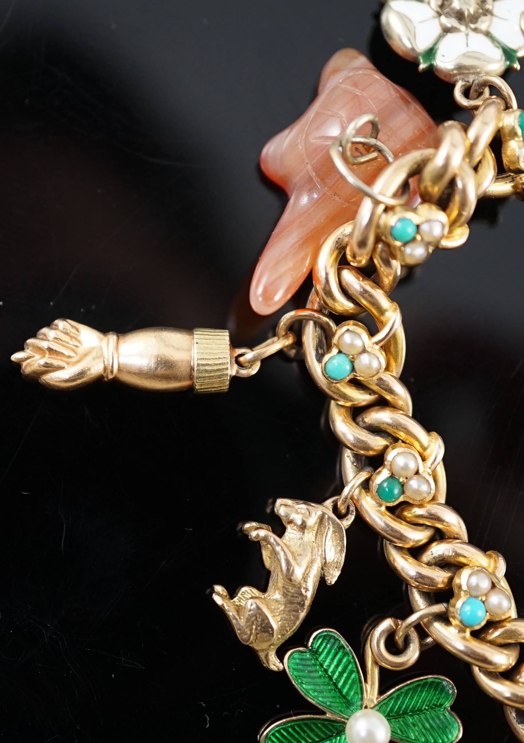 An Edwardian 15ct gold, seed pearl and turquoise set curb link charm bracelet